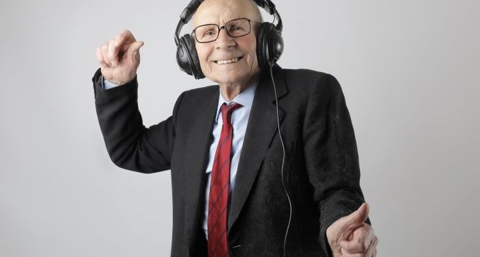 Elderly retireee in black suit dancing
